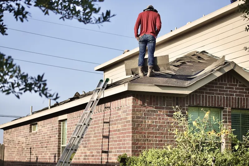 Professional roofer working on a residential roof in Inwood-Northwest